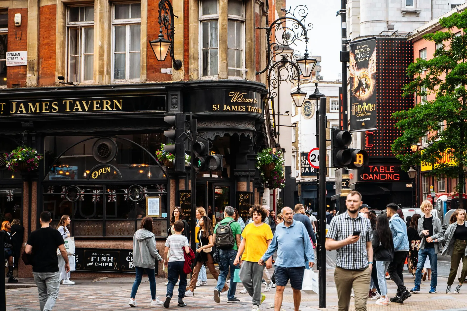 Friends walking through a warmly lit English urban quarter